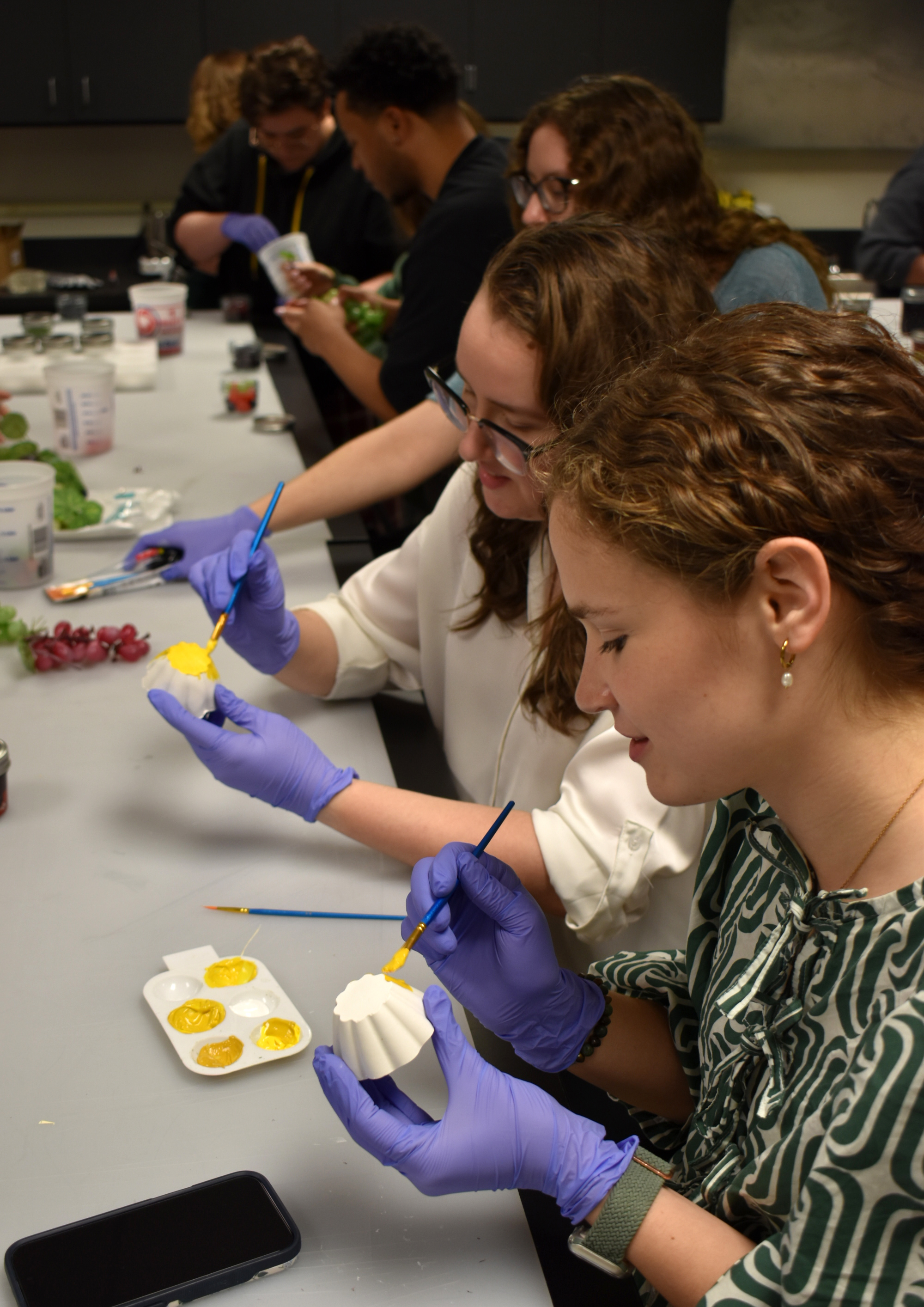 Students painting fake food for an exhibit. 